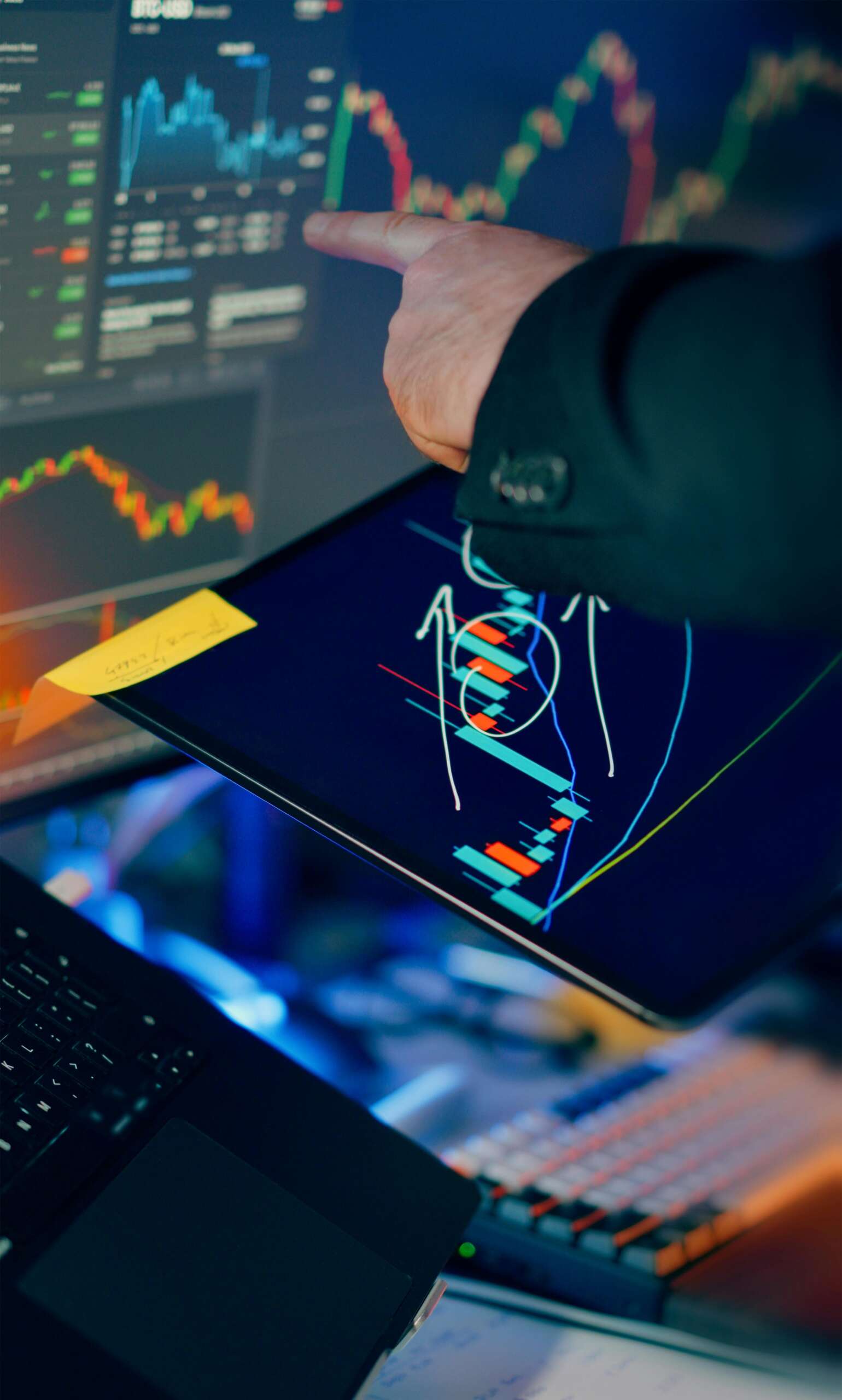 Investor analyzing stock market charts on tablet and laptop