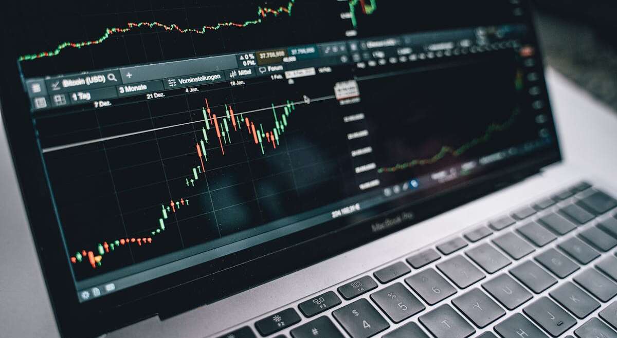 Laptop showing financial trading charts and analysis
