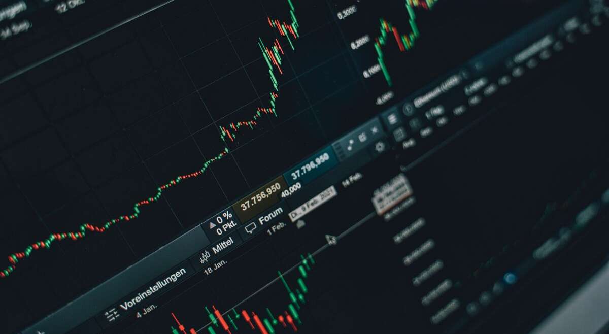 Person analyzing cryptocurrency trading charts on a laptop