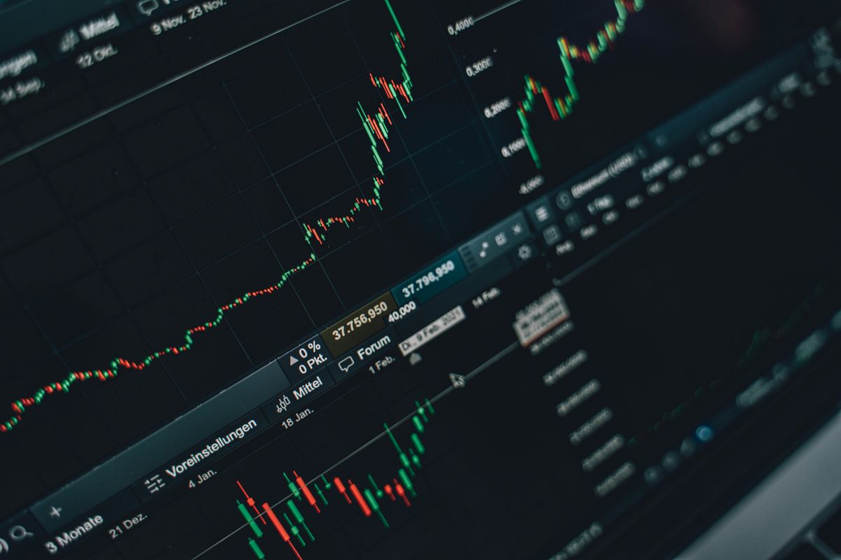 Person analyzing cryptocurrency trading charts on a laptop